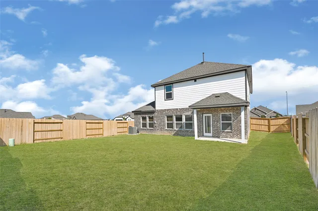 a view of a house with a big yard and large trees