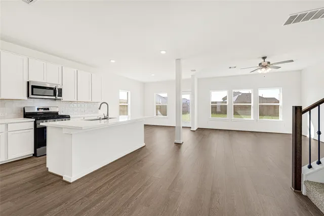 a large white kitchen with wooden floors
