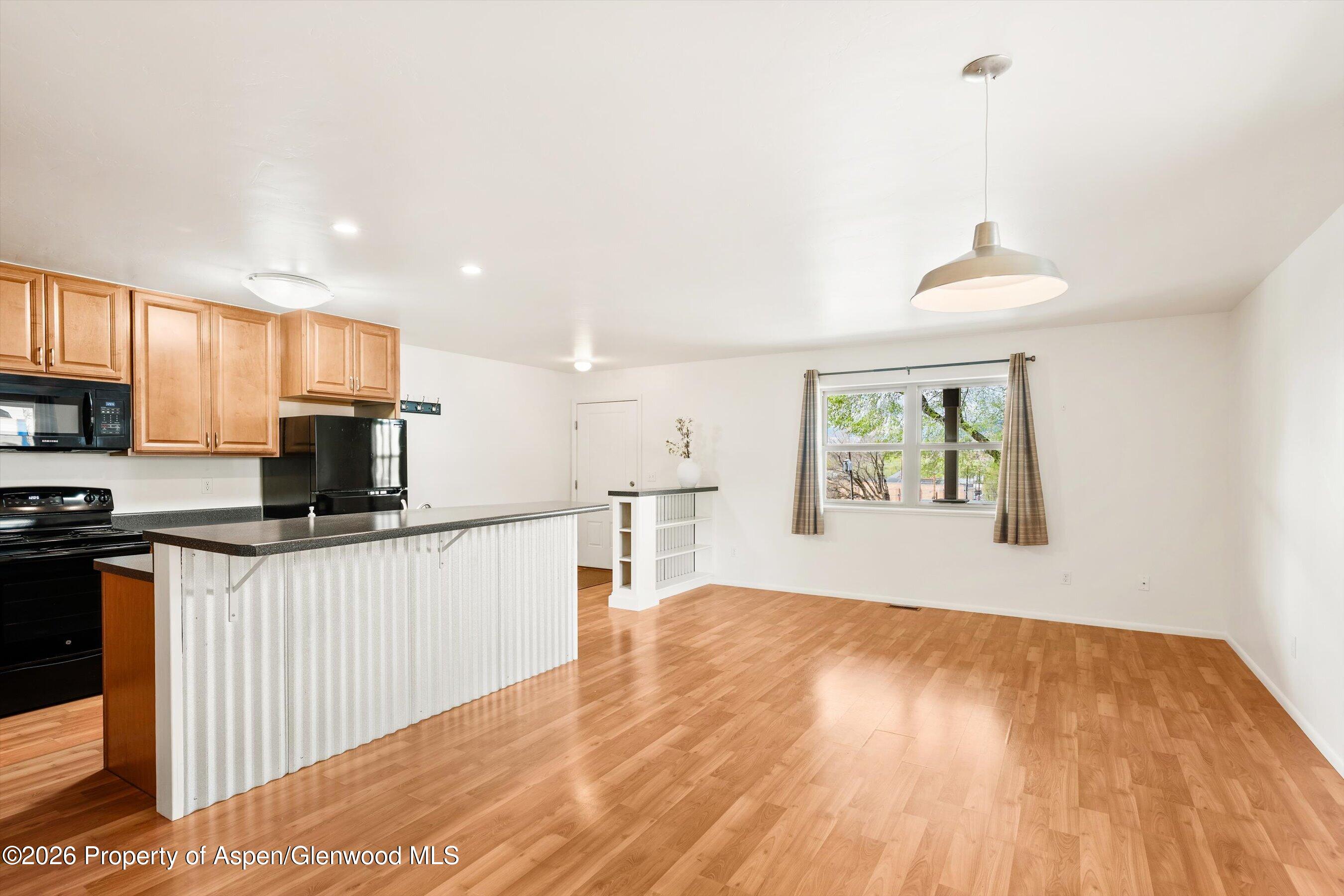 430-432 Whiteriver Avenue Rifle, CO 81650 - Photo 17 of 27 a kitchen with a sink wooden floor and a refrigerator