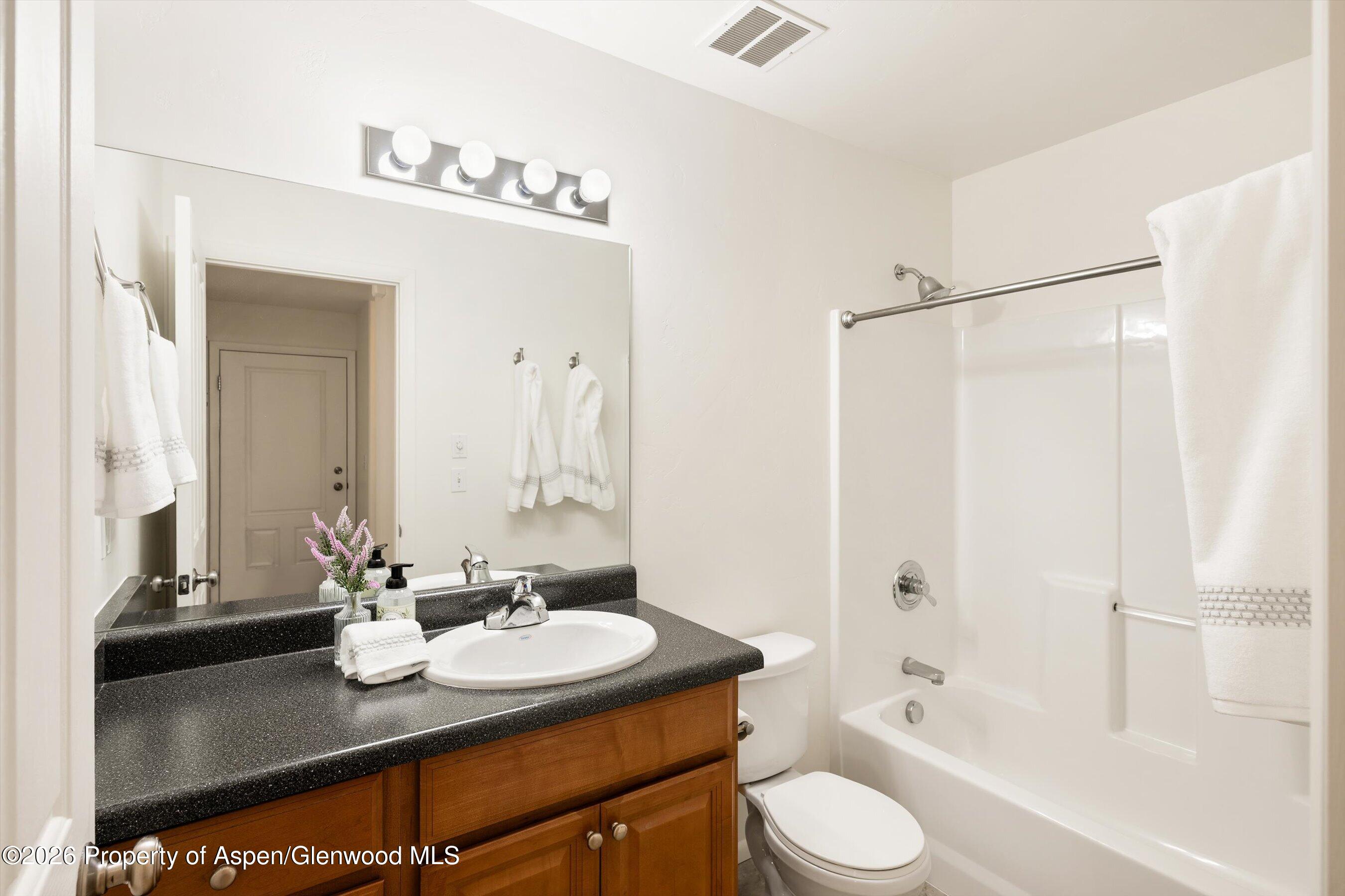 430-432 Whiteriver Avenue Rifle, CO 81650 - Photo 19 of 27 a bathroom with a granite countertop sink toilet a mirror and shower