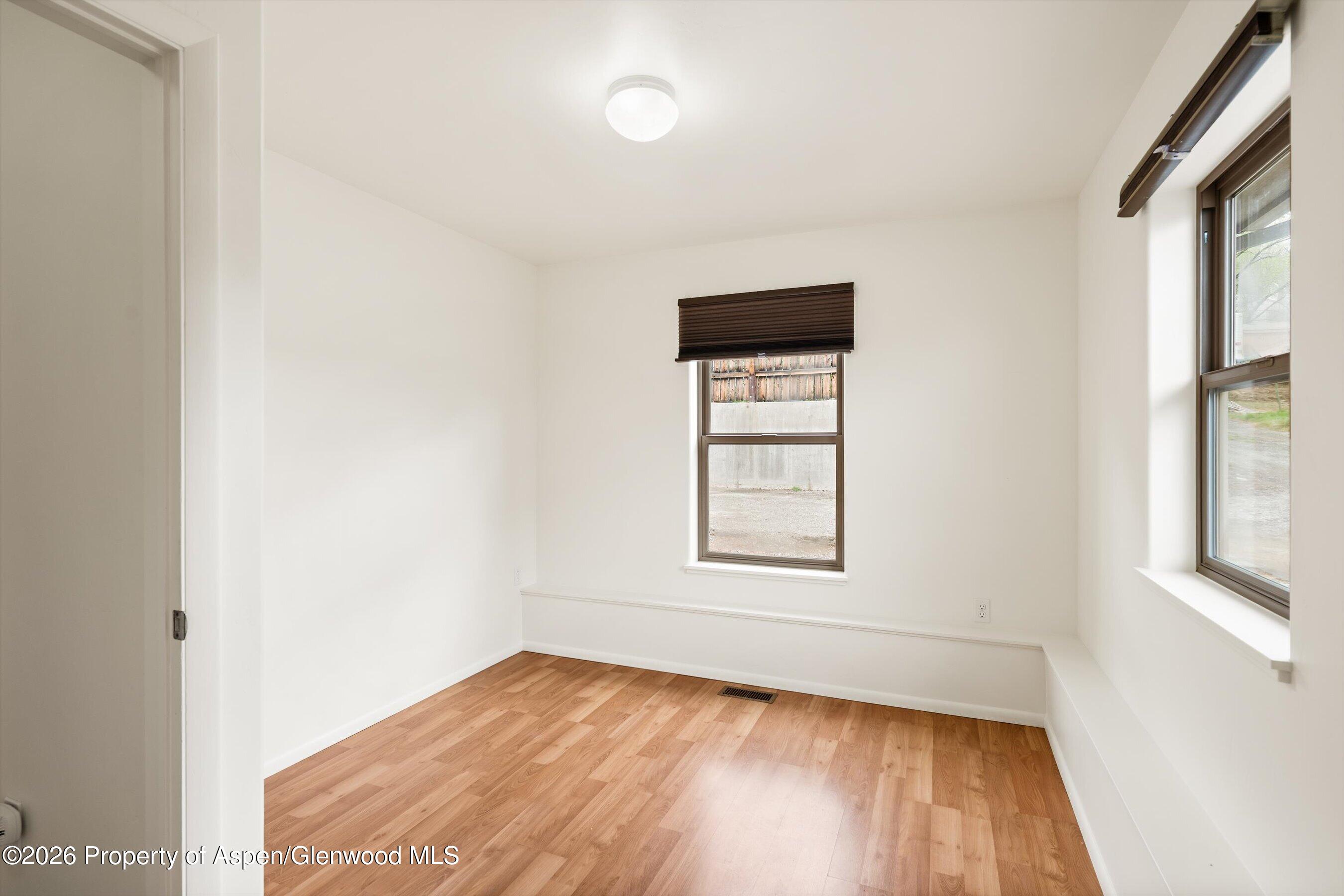 430-432 Whiteriver Avenue Rifle, CO 81650 - Photo 22 of 27 an empty room with wooden floor and windows