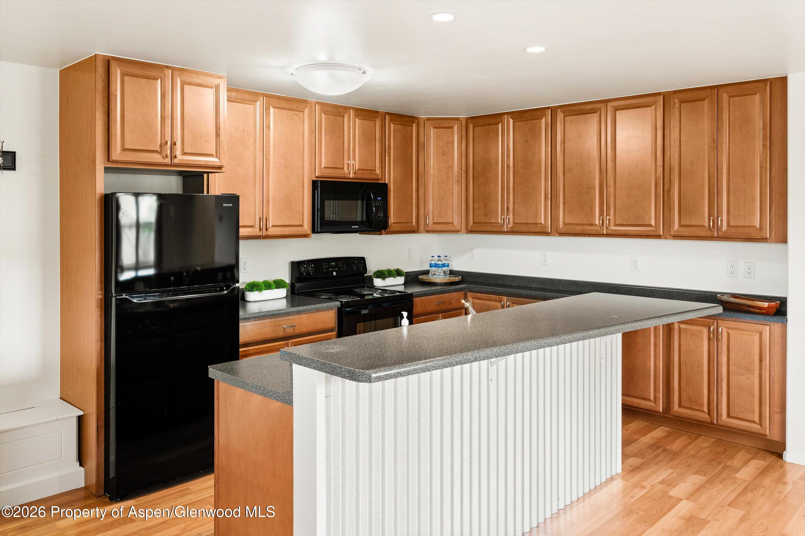 430-432 Whiteriver Avenue Rifle, CO 81650 - Photo 4 of 27 a kitchen with granite countertop a refrigerator stove and microwave