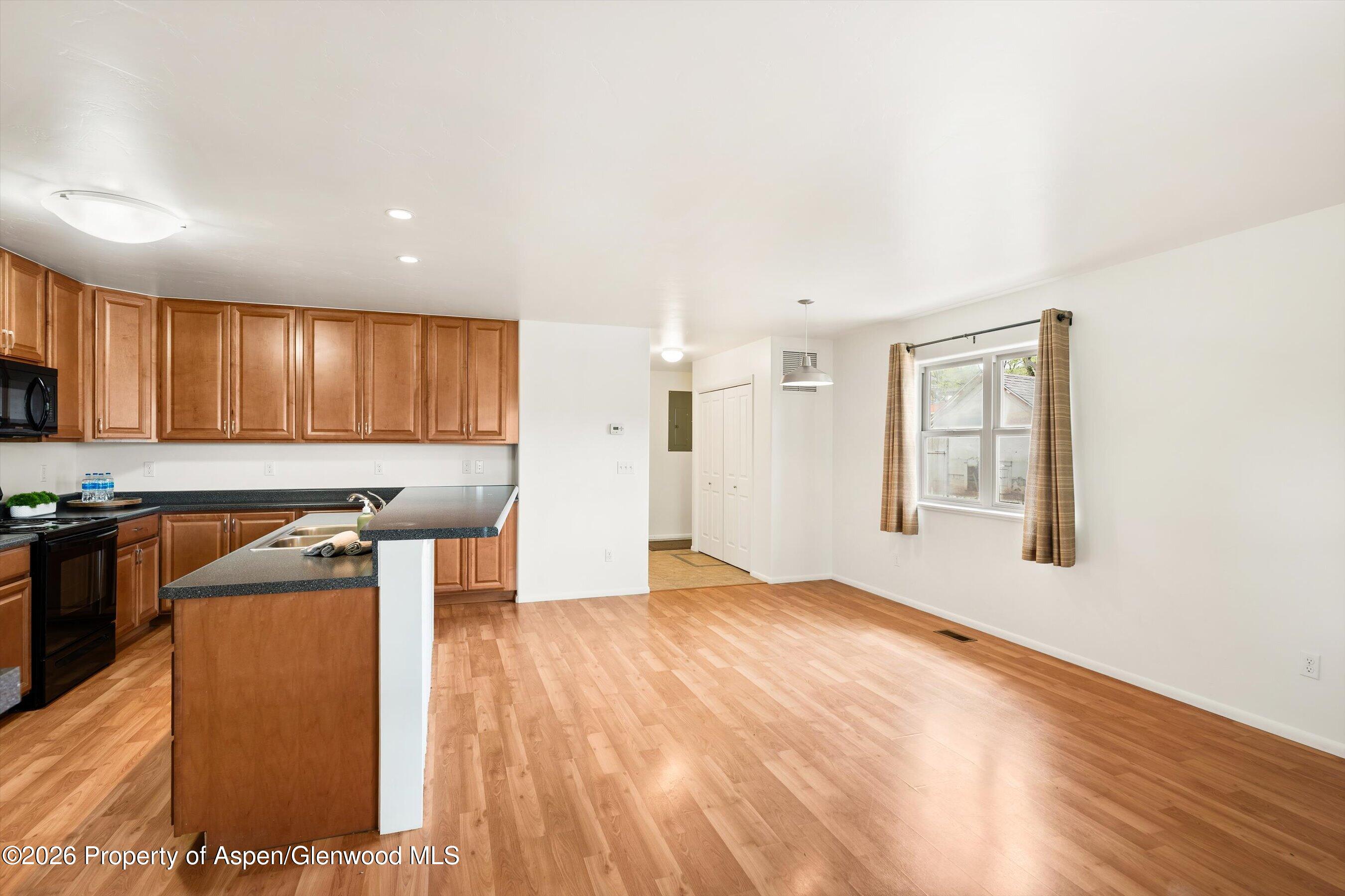 430-432 Whiteriver Avenue Rifle, CO 81650 - Photo 5 of 27 a kitchen with stainless steel appliances granite countertop a stove a sink and a refrigerator with wooden floor