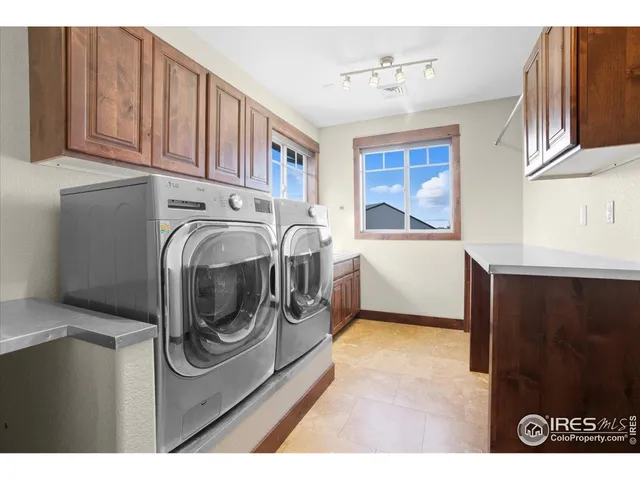a large white kitchen with stainless steel appliances granite countertop a stove a sink and a refrigerator