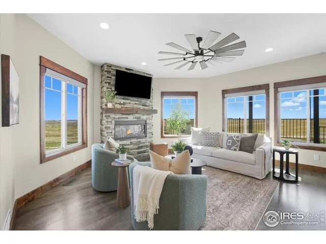 a living room with furniture a flat screen tv and wooden floor
