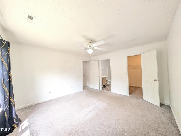 a view of an empty room with a ceiling fan