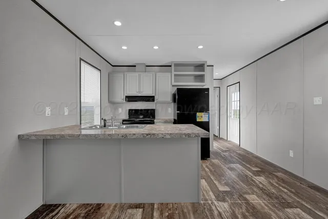 a kitchen with kitchen island a sink stainless steel appliances and cabinets