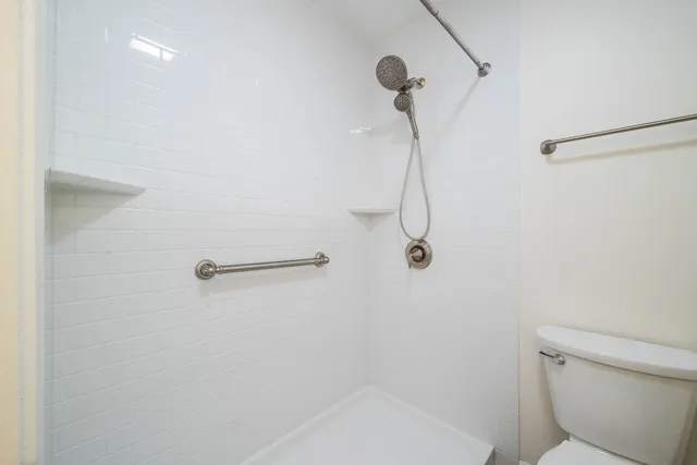 a bathroom with a granite countertop sink a toilet and a mirror