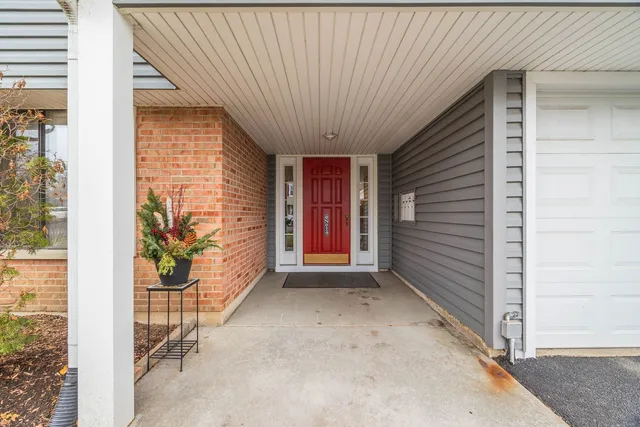 a view of an empty room with wooden floor and a fireplace