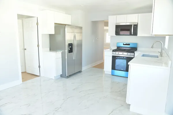 a kitchen with stainless steel appliances granite countertop a sink stove and microwave