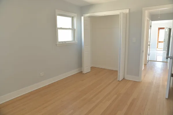 an empty room with wooden floor and a window