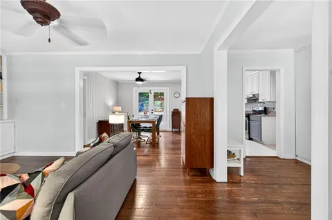 a living room with furniture and a wooden floor