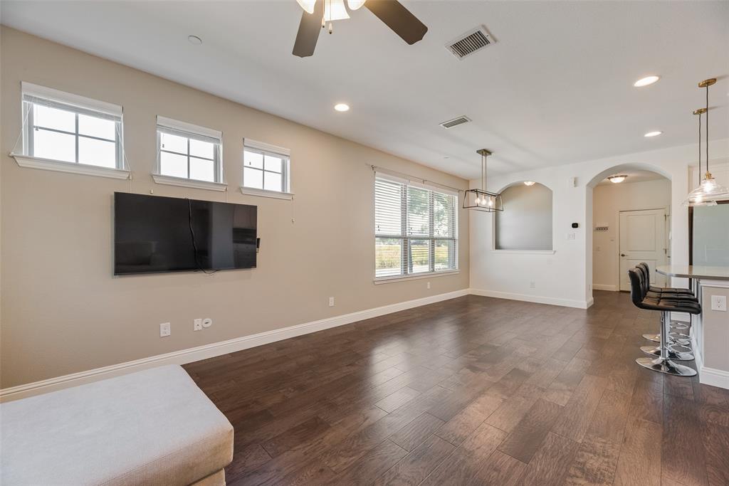 4670 I Rhett Lane, Unit I Carrollton, TX 75010 - Photo 8 of 31 Wood-finish flooring throughout, featuring a ceiling fan with integrated lighting, recessed lighting, and large windows
