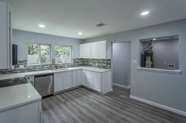 a kitchen with a refrigerator and white cabinets