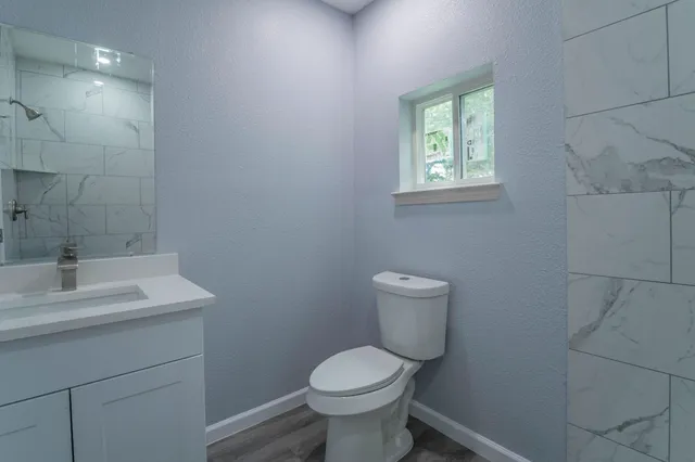 a bathroom with a toilet sink and mirror