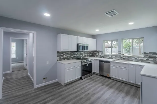 a kitchen with granite countertop white cabinets and white appliances