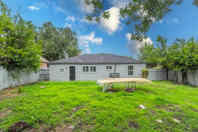 a backyard of a house with a swing and plants