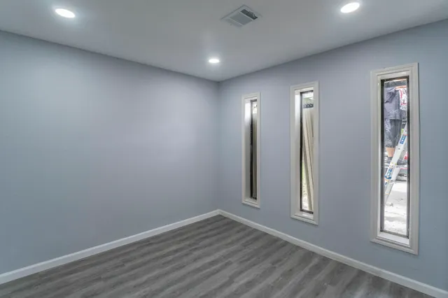 an empty room with wooden floor and window