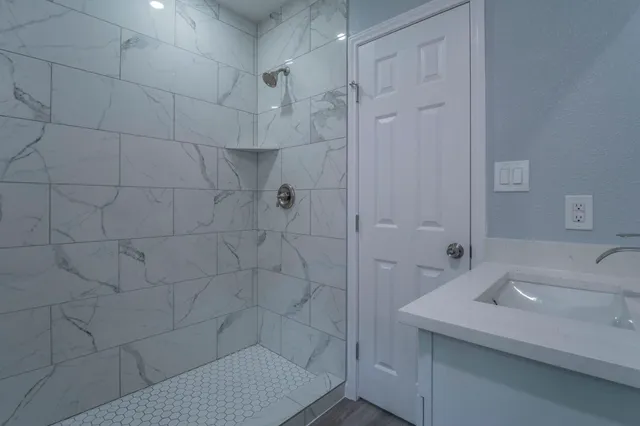 a bathroom with a sink shower and a mirror