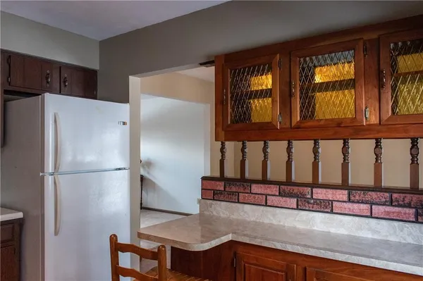 a kitchen with stainless steel appliances granite countertop a refrigerator a stove and a sink with large cabinets