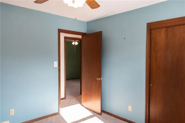 an empty room with closet and a chandelier fan