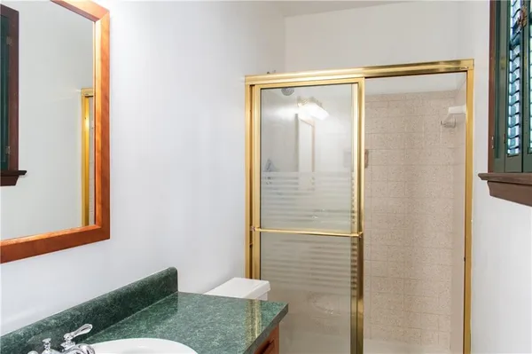 a bathroom with a granite countertop shower and a sink