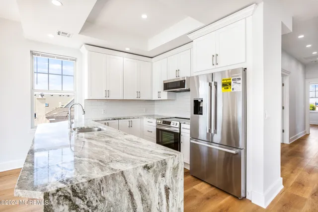 a kitchen with a refrigerator a stove a microwave and cabinets