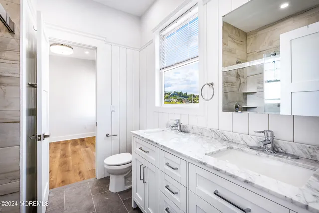 a bathroom with a granite countertop sink toilet and shower