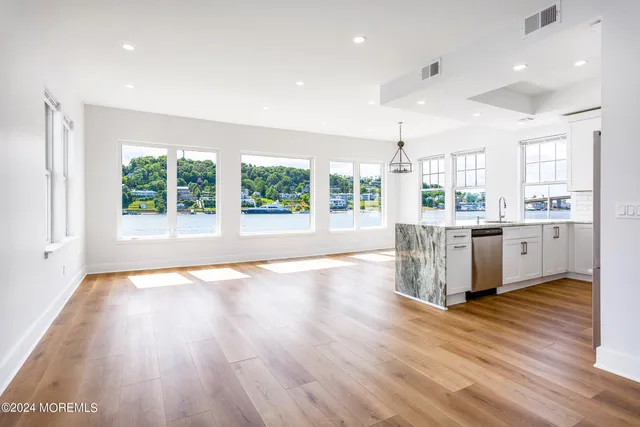 a room with stainless steel appliances wooden floors and view living room