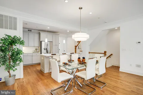 a view of a dining room and livingroom with furniture wooden floor a chandelier
