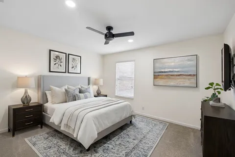 a bedroom with a large bed and a lamp on dresser