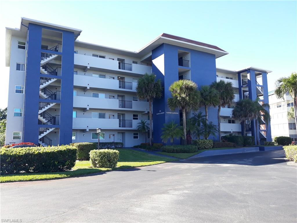 190 Pebble Beach Boulevard, Unit 503 Naples, FL 34113 - Photo 1 of 17 a view of a tall building with a big yard and large trees