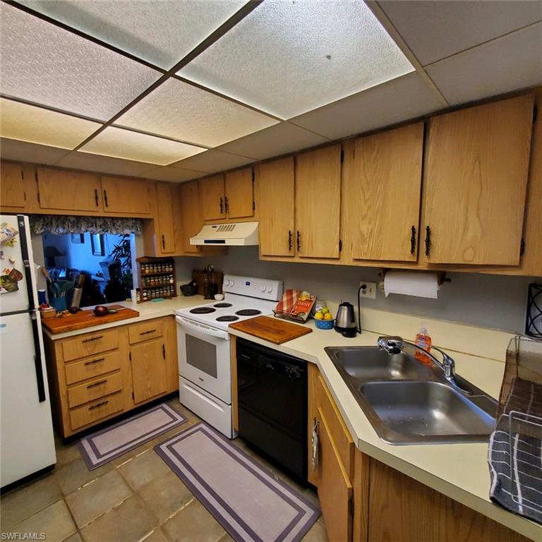 190 Pebble Beach Boulevard, Unit 503 Naples, FL 34113 - Photo 4 of 17 a kitchen with a sink stove top oven and cabinets