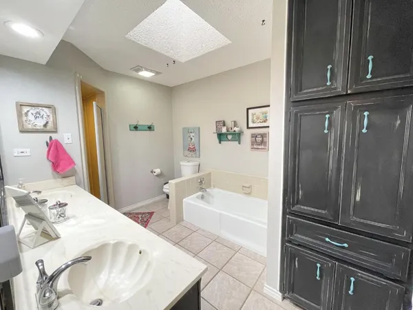 a en suite bathroom with a tub sink and mirror