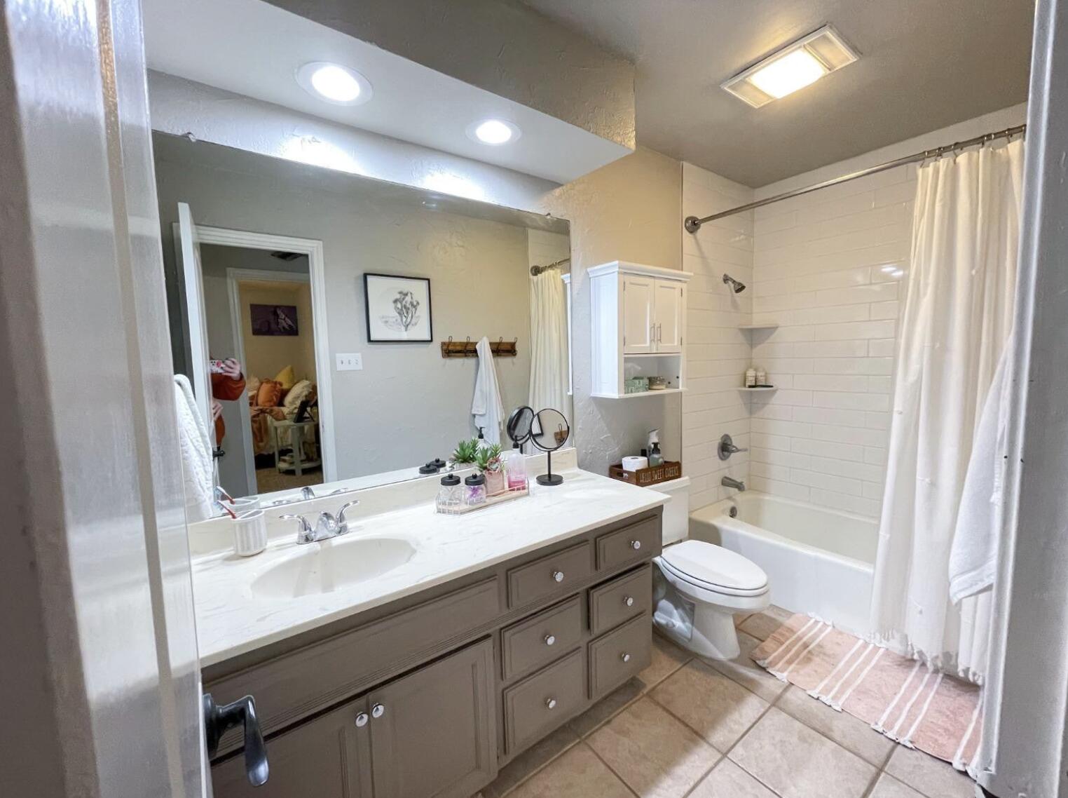 5413 83rd Street Lubbock, TX 79424 - Photo 15 of 21 a bathroom with a double vanity sink toilet mirror and bathtub