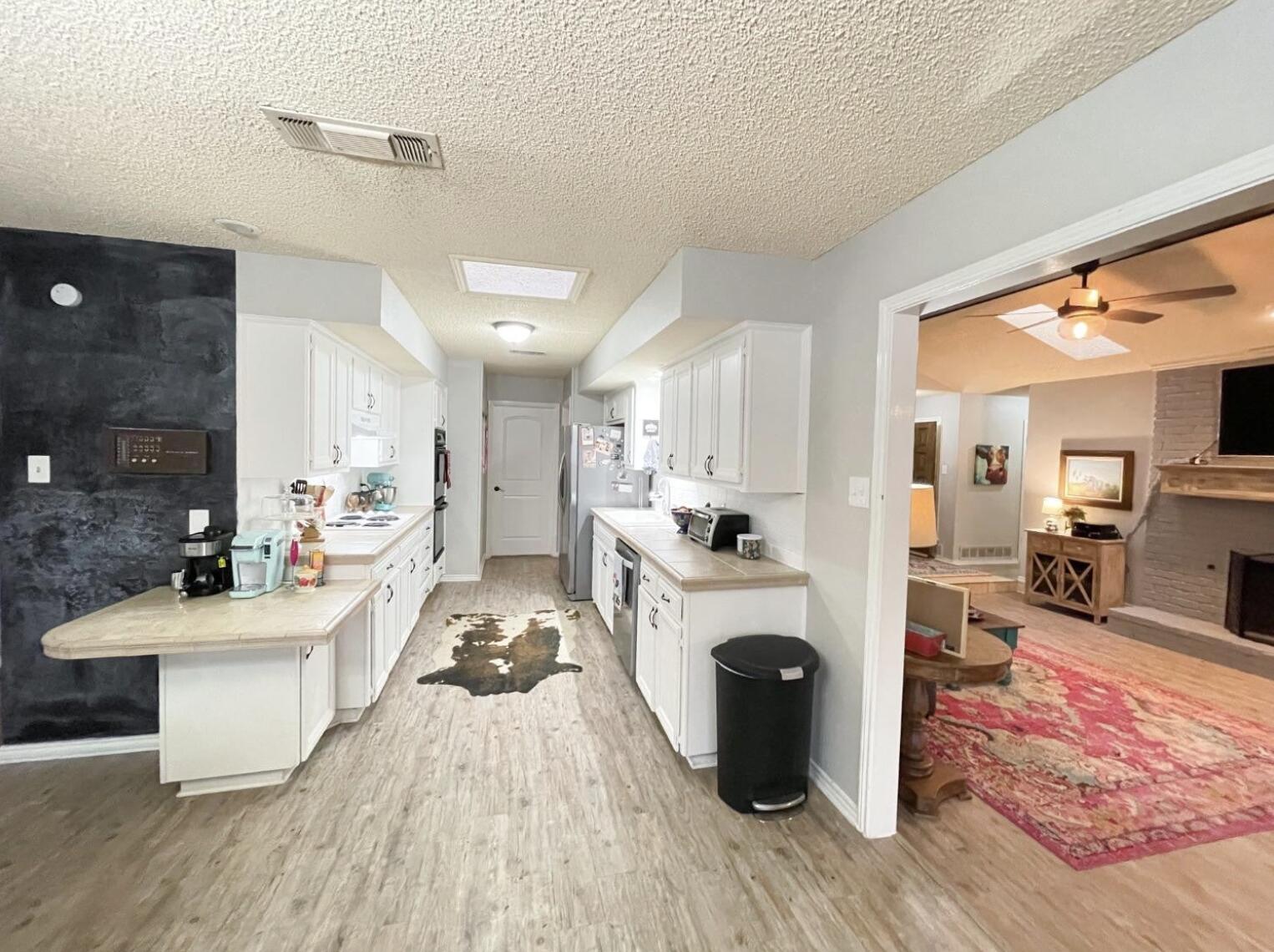 5413 83rd Street Lubbock, TX 79424 - Photo 5 of 21 a living room with furniture a fireplace and a flat screen tv