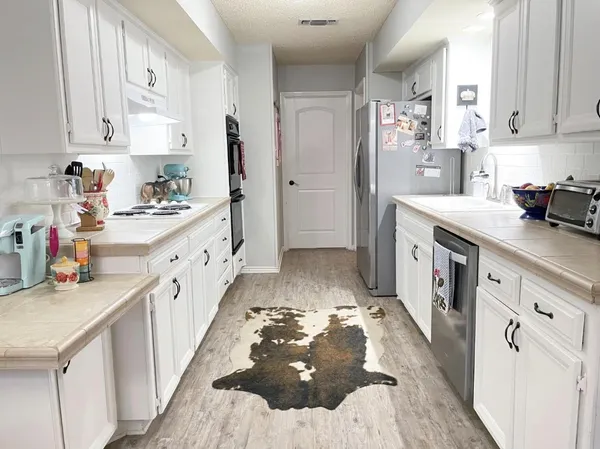 a kitchen with sink cabinets and refrigerator