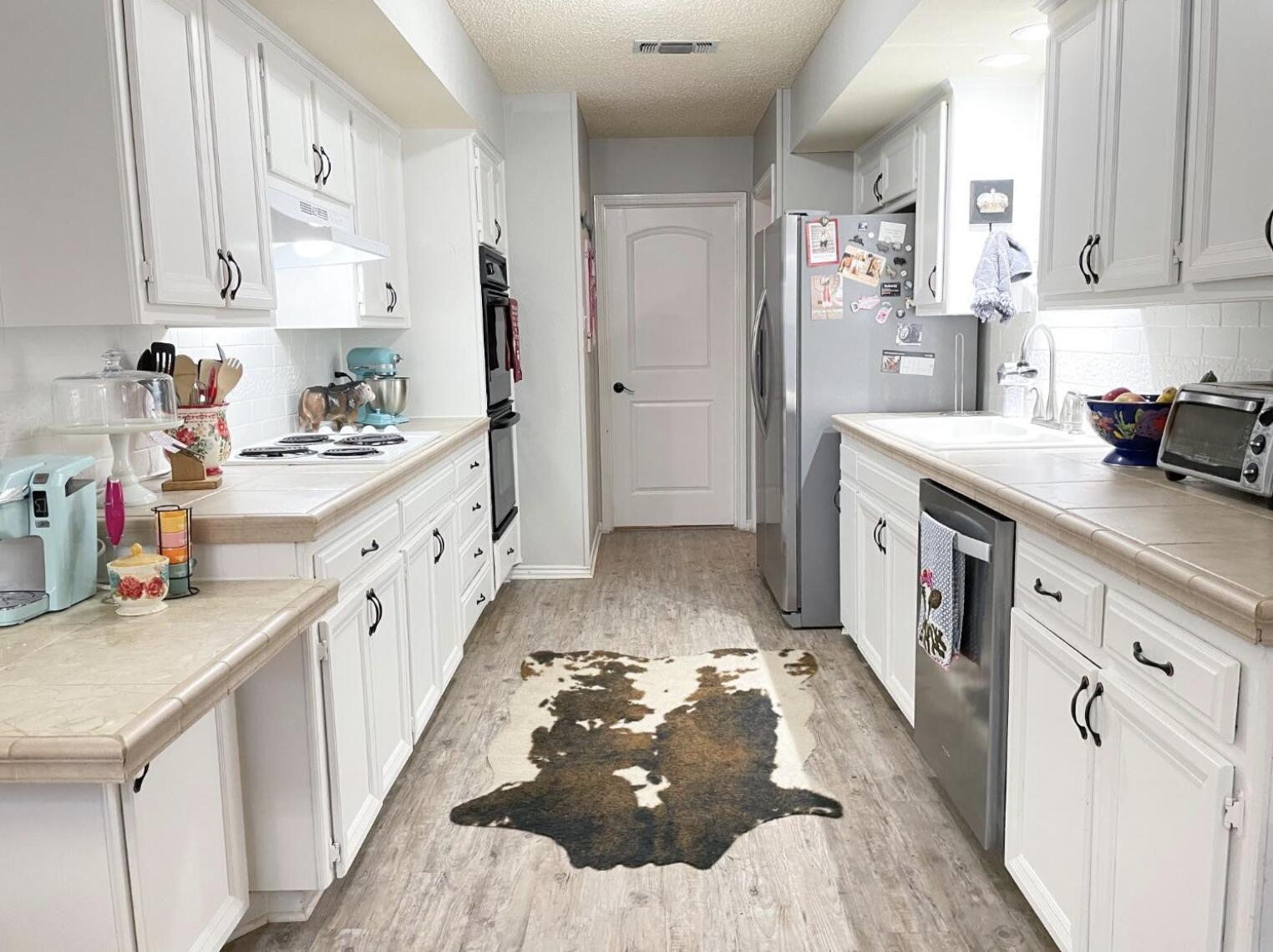 5413 83rd Street Lubbock, TX 79424 - Photo 6 of 21 a kitchen with sink cabinets and refrigerator