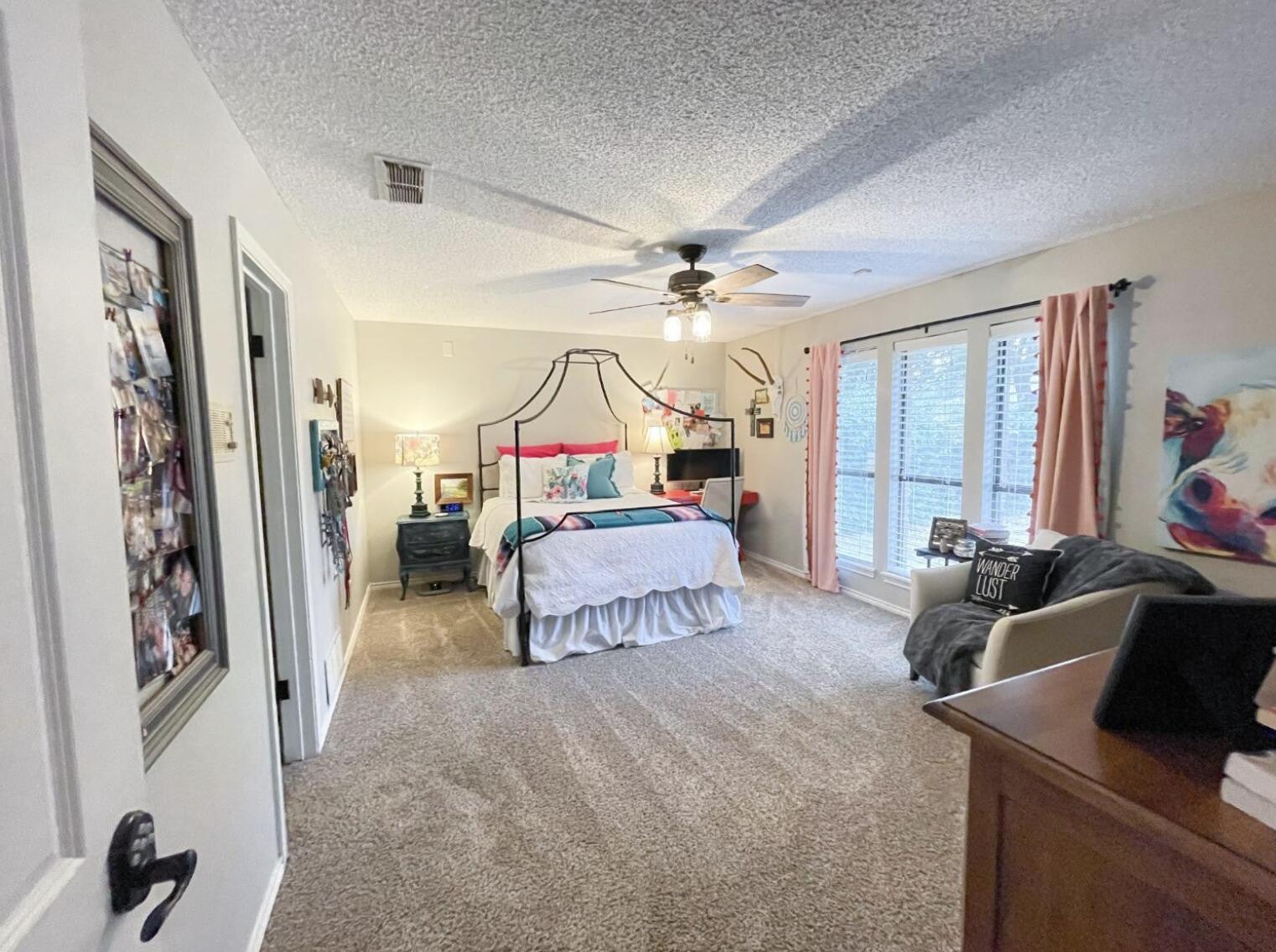 5413 83rd Street Lubbock, TX 79424 - Photo 9 of 21 a bedroom with furniture and a chandelier