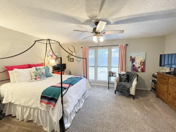 a bedroom with a bed a chandelier and couch