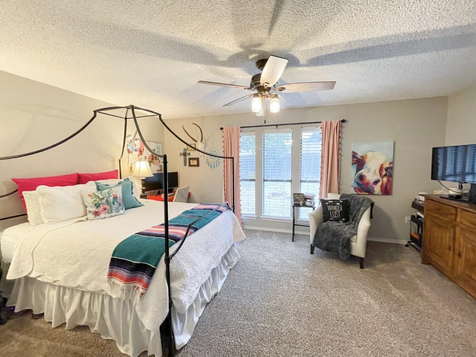 5413 83rd Street Lubbock, TX 79424 - Photo 10 of 21 a bedroom with a bed a chandelier and couch