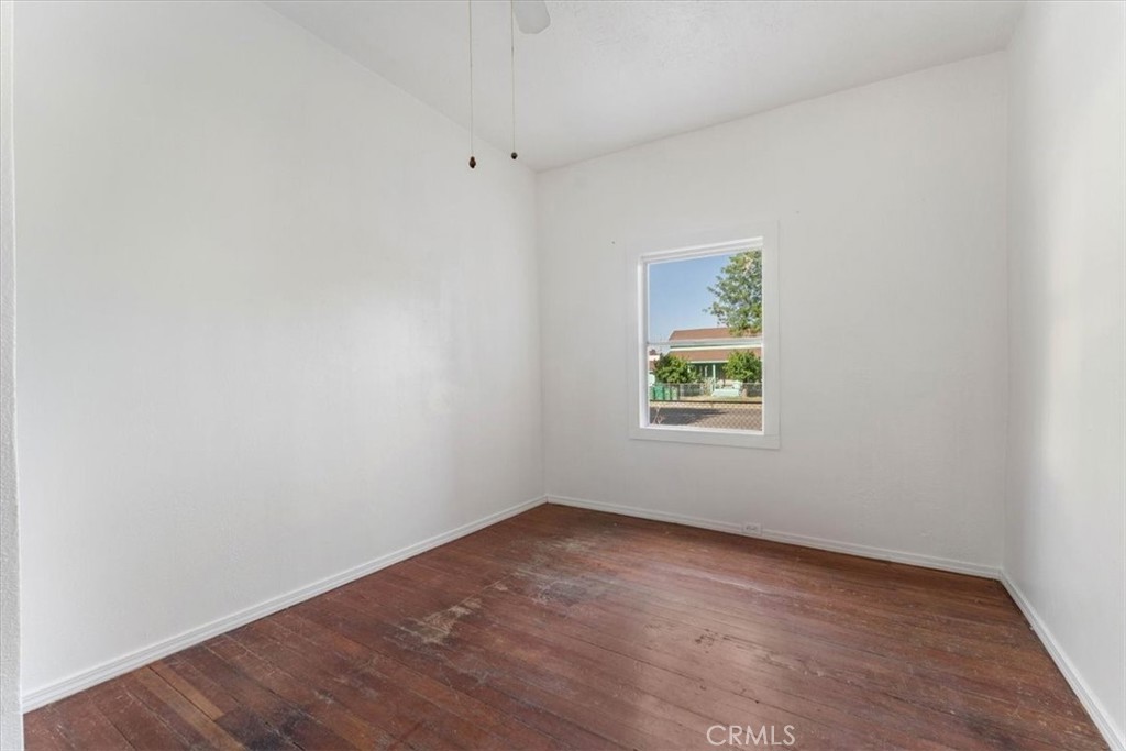 818 6th Street Corning, CA 96021 - Photo 17 of 36 an empty room with wooden floor and a window