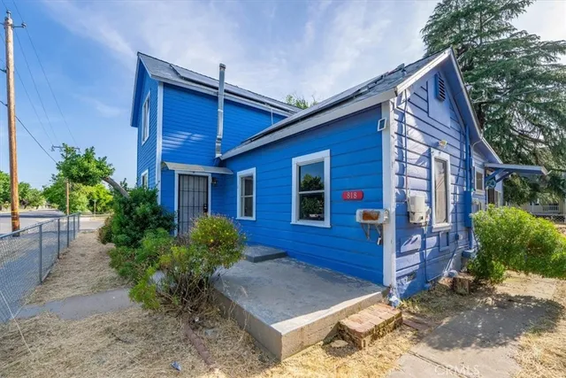 a view of brick house with a yard and plants