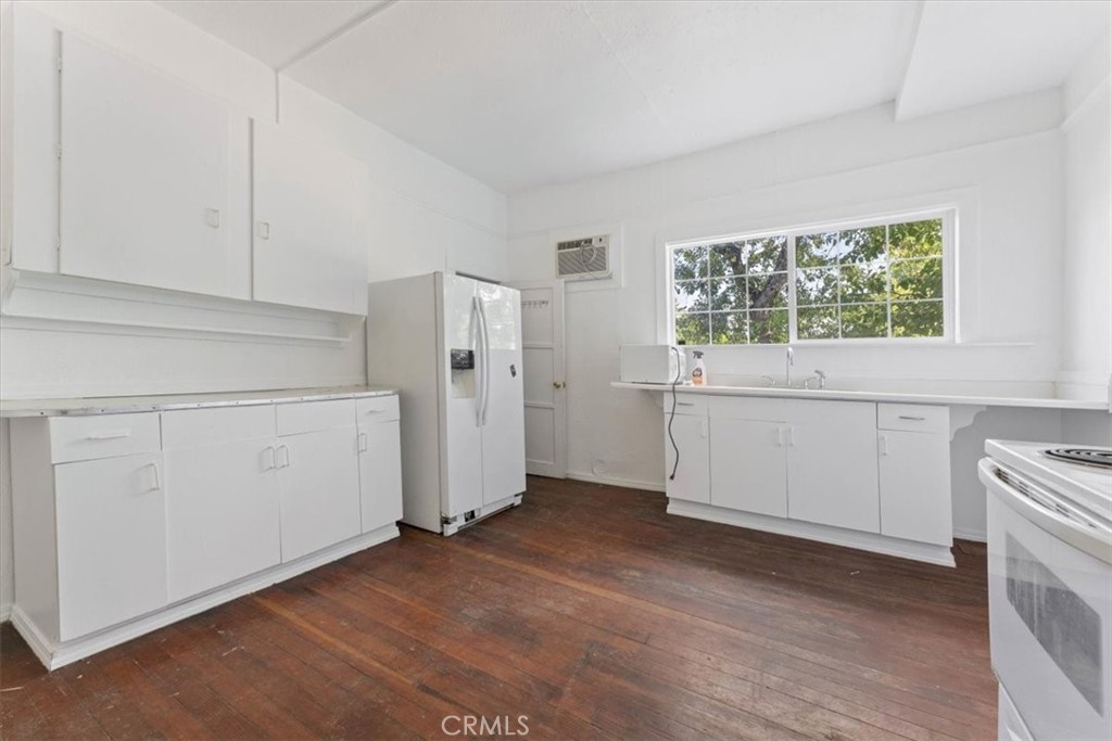 818 6th Street Corning, CA 96021 - Photo 5 of 36 a view of a kitchen with white cabinets and wooden floor