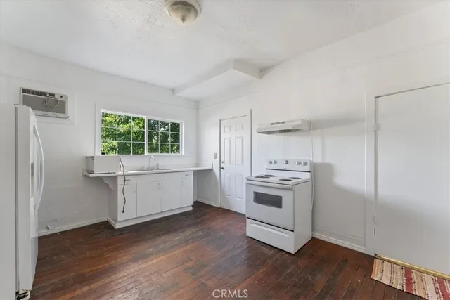 a kitchen with a stove cabinets and wooden floor