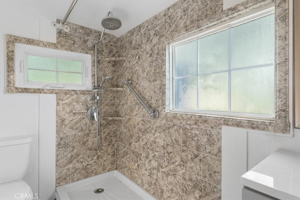 818 6th Street Corning, CA 96021 - Photo 9 of 36 a bathroom with a granite countertop sink a toilet and shower