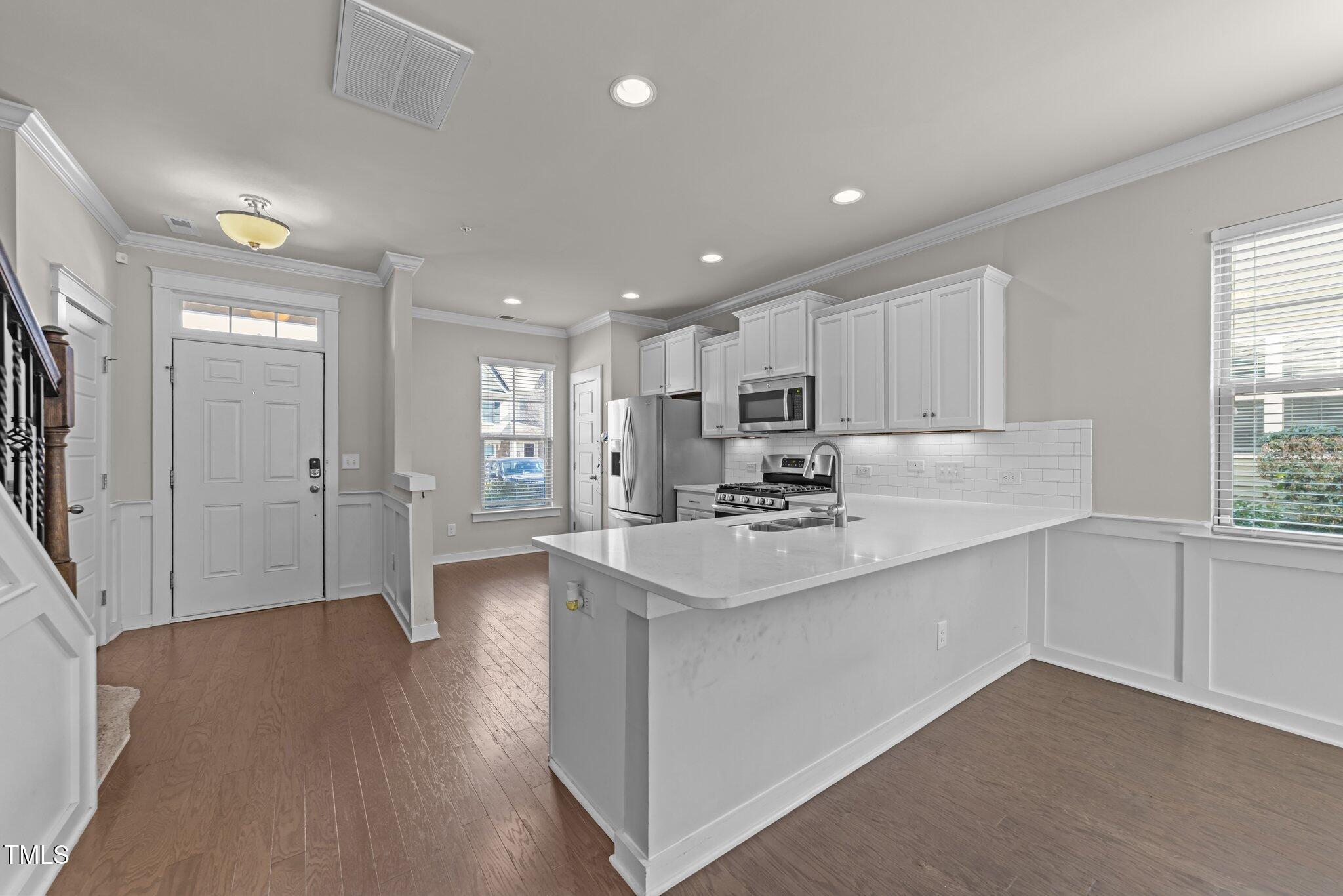 7824 Allscott Way Raleigh, NC 27612 - Photo 7 of 26 a kitchen with stainless steel appliances a sink stove and cabinets