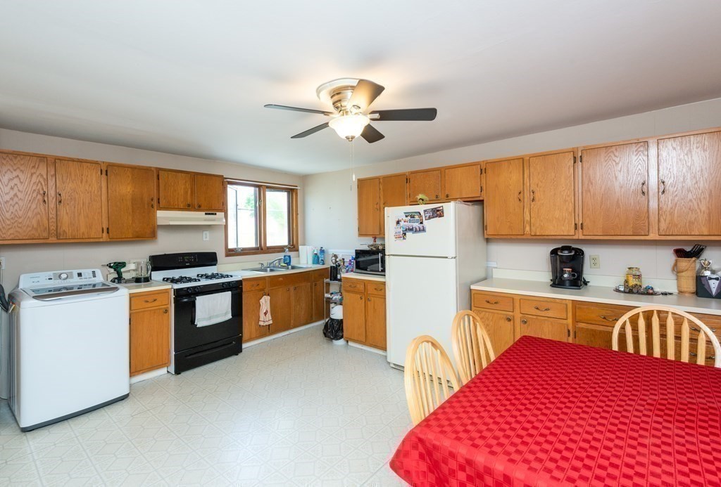 46 Holten Street Peabody, MA 01960 - Photo 27 of 41 a kitchen with stainless steel appliances granite countertop a refrigerator a stove top oven a sink dishwasher and white cabinets with wooden floor