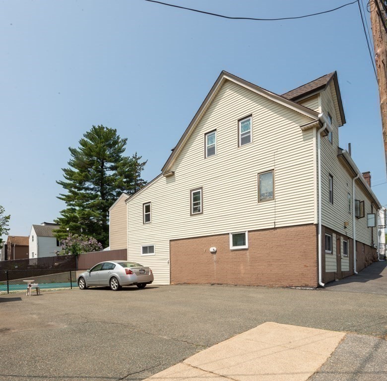 46 Holten Street Peabody, MA 01960 - Photo 40 of 41 a view of a house with a yard and parking space