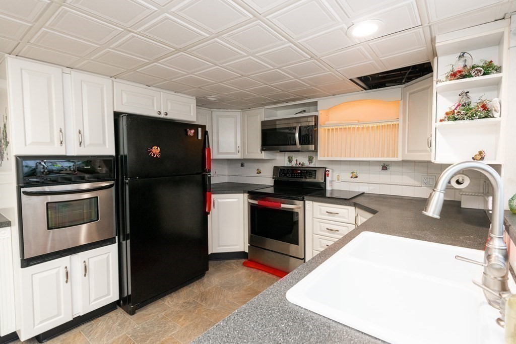 46 Holten Street Peabody, MA 01960 - Photo 8 of 41 a kitchen with granite countertop a refrigerator stove top oven and sink